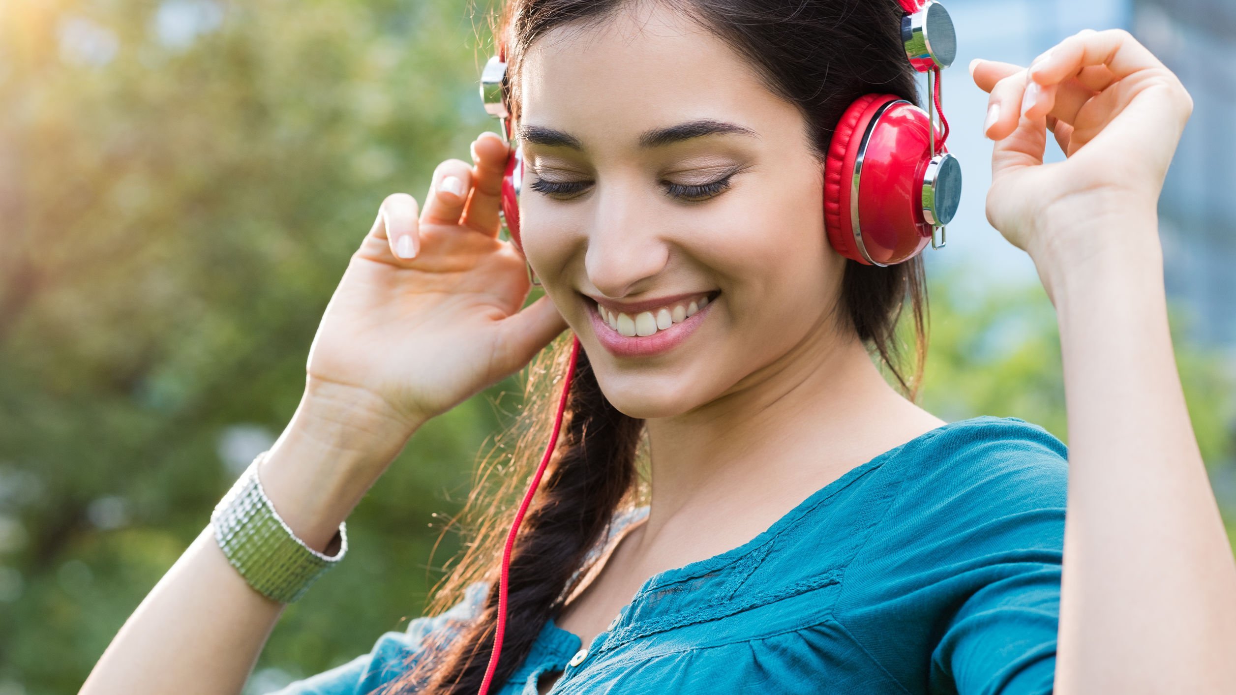 Mulher sorrindo, ouvindo música.