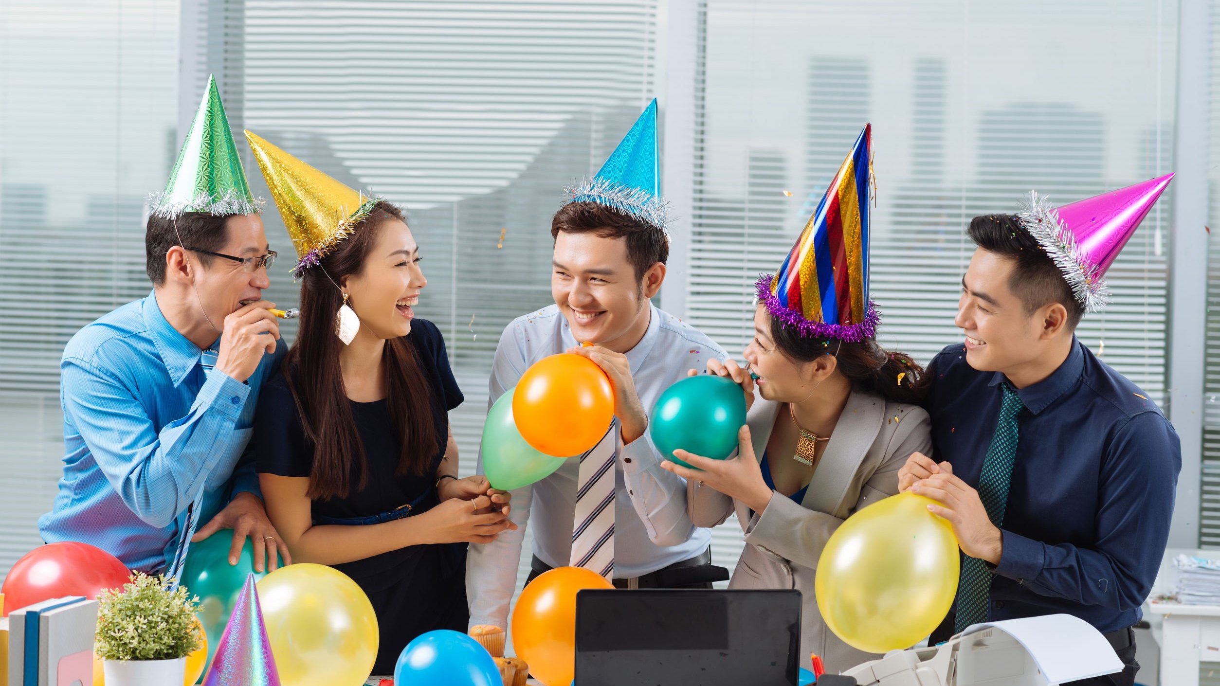 Pessoas em escritório comemorando aniversário da empresa.