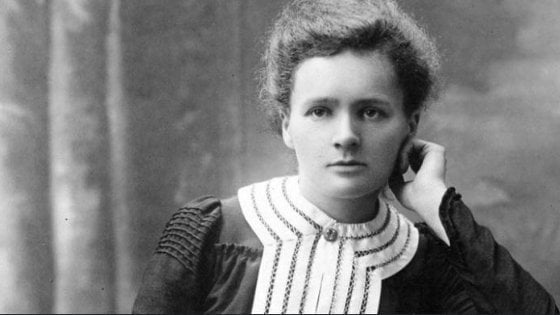 Marie Curie olhando para o lado apoiando seu queixo na mão