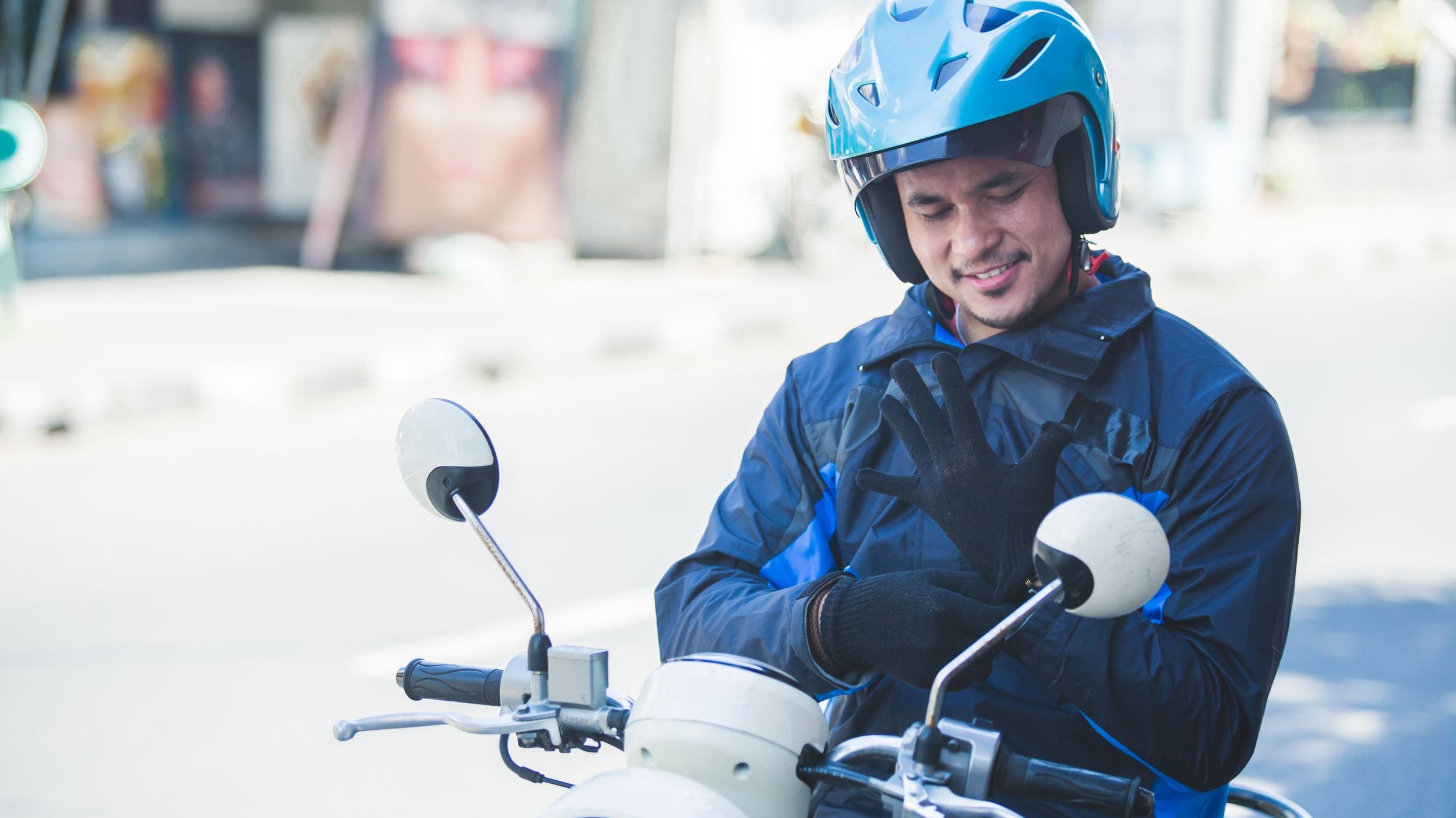 Homem em moto,  vestindo par de luvas