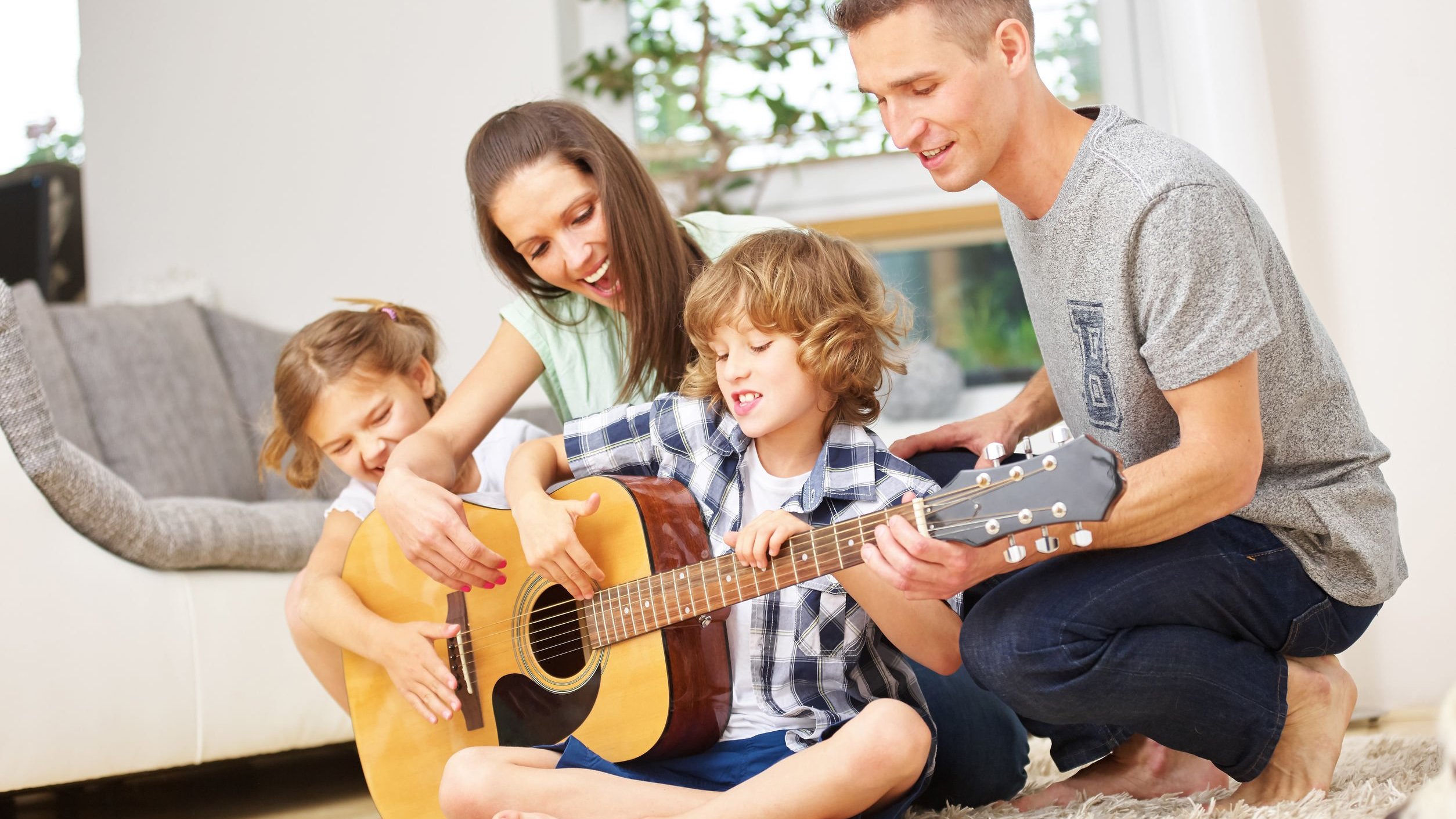 Família reunida tocando violão.