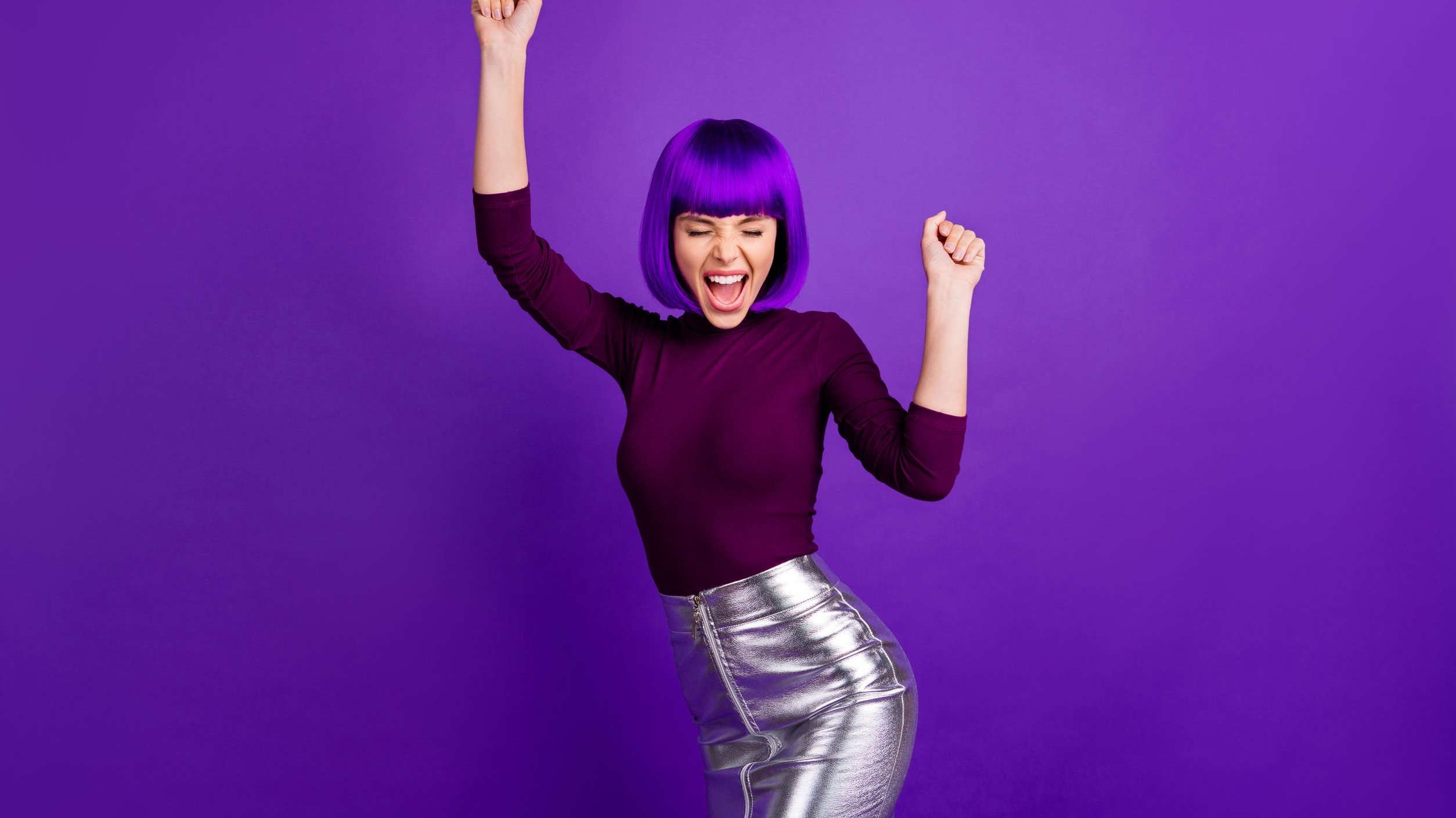 Mulher de cabelo roxo sorrindo.