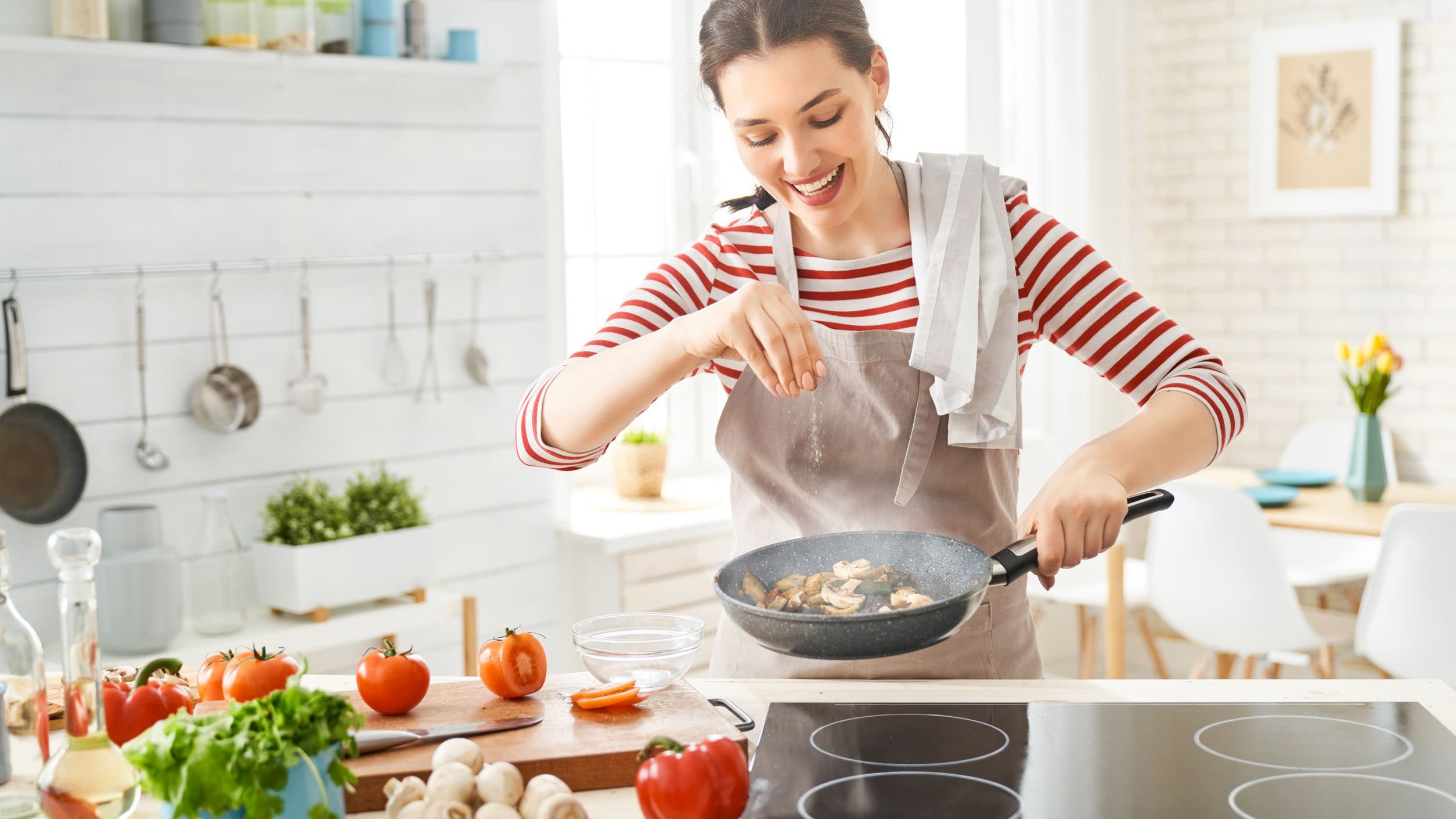 Dona de casa sorri enquanto cozinha