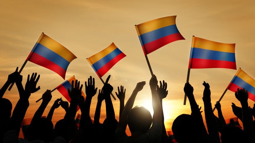 Pessoas segurando bandeiras da Colômbia