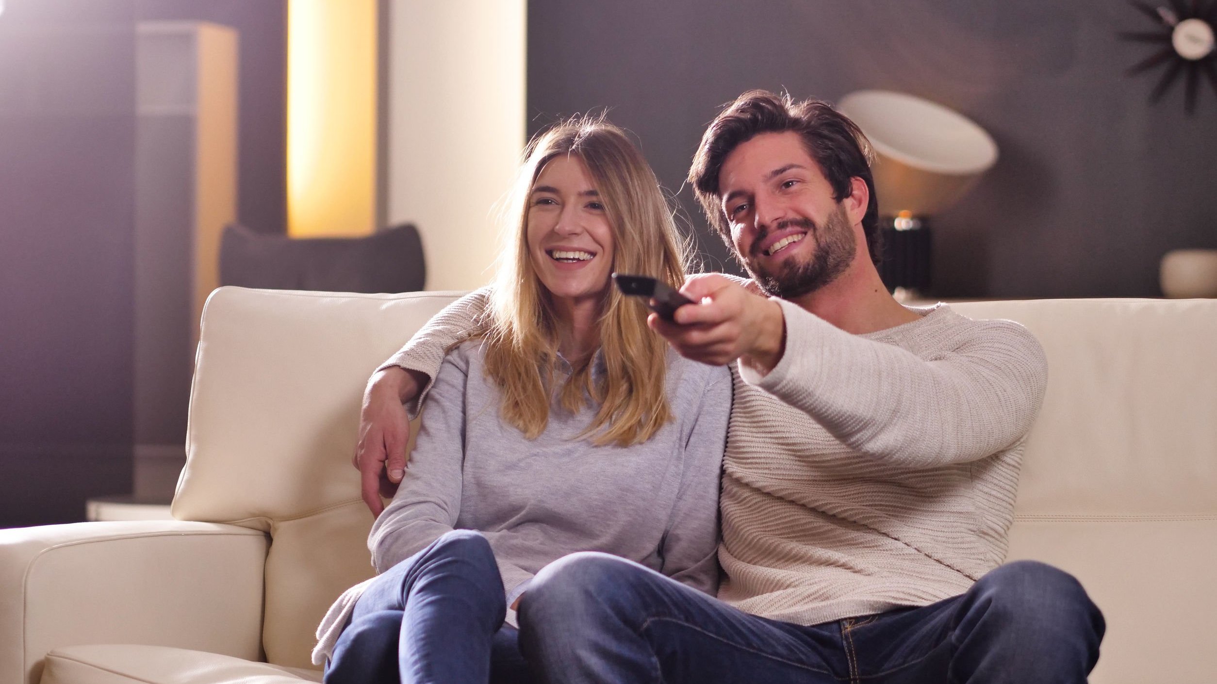 Homem e mulher sorrindo, assistindo filme.