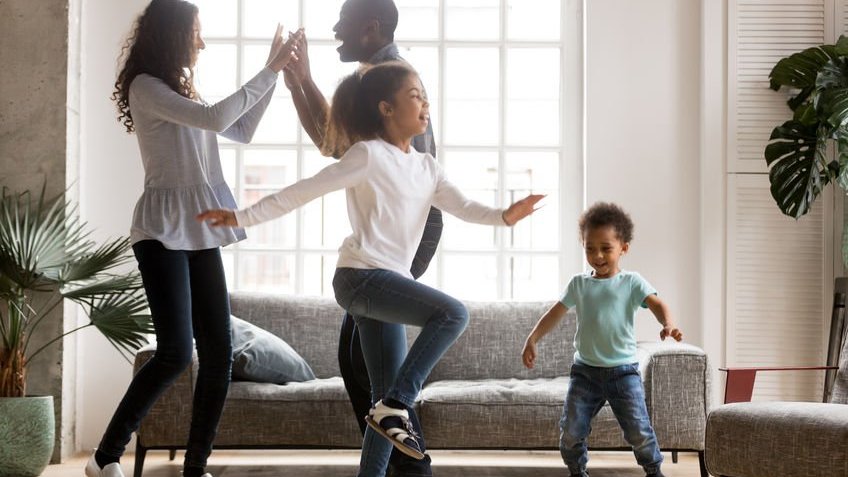 Família dançando na sala de casa