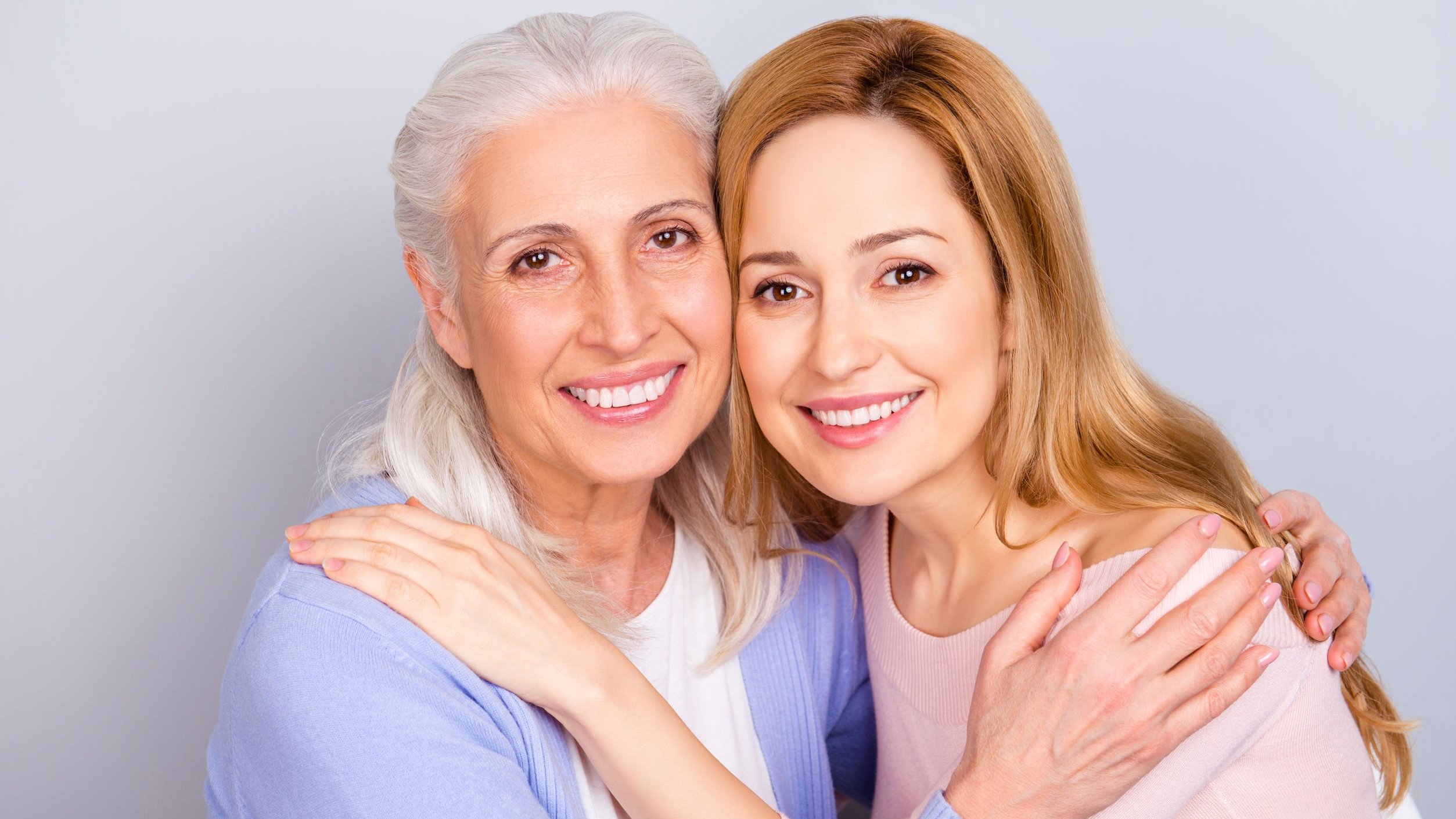 Mulheres sorrindo e se abraçando.