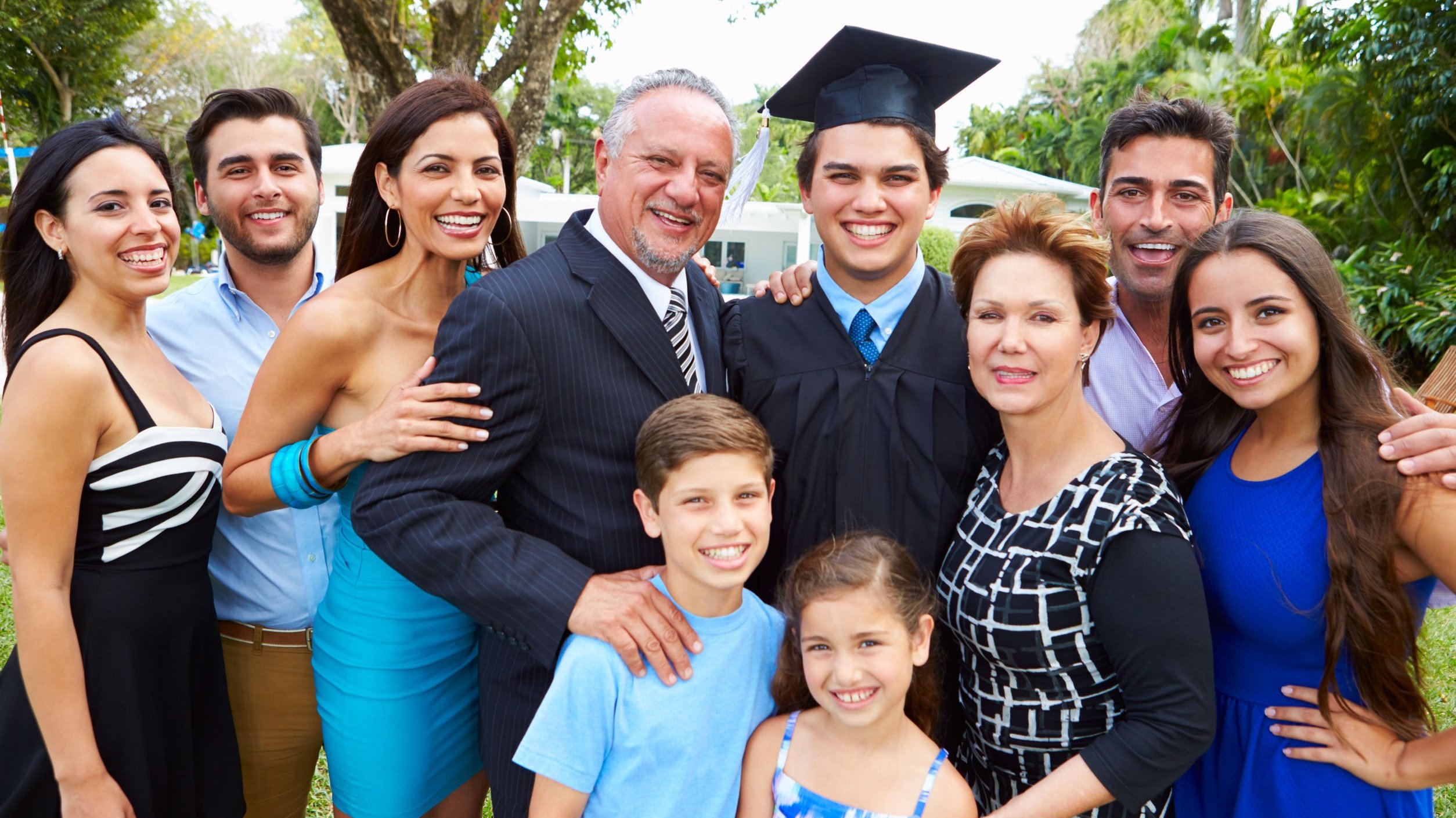 Família sorrindo em foto de formatura.