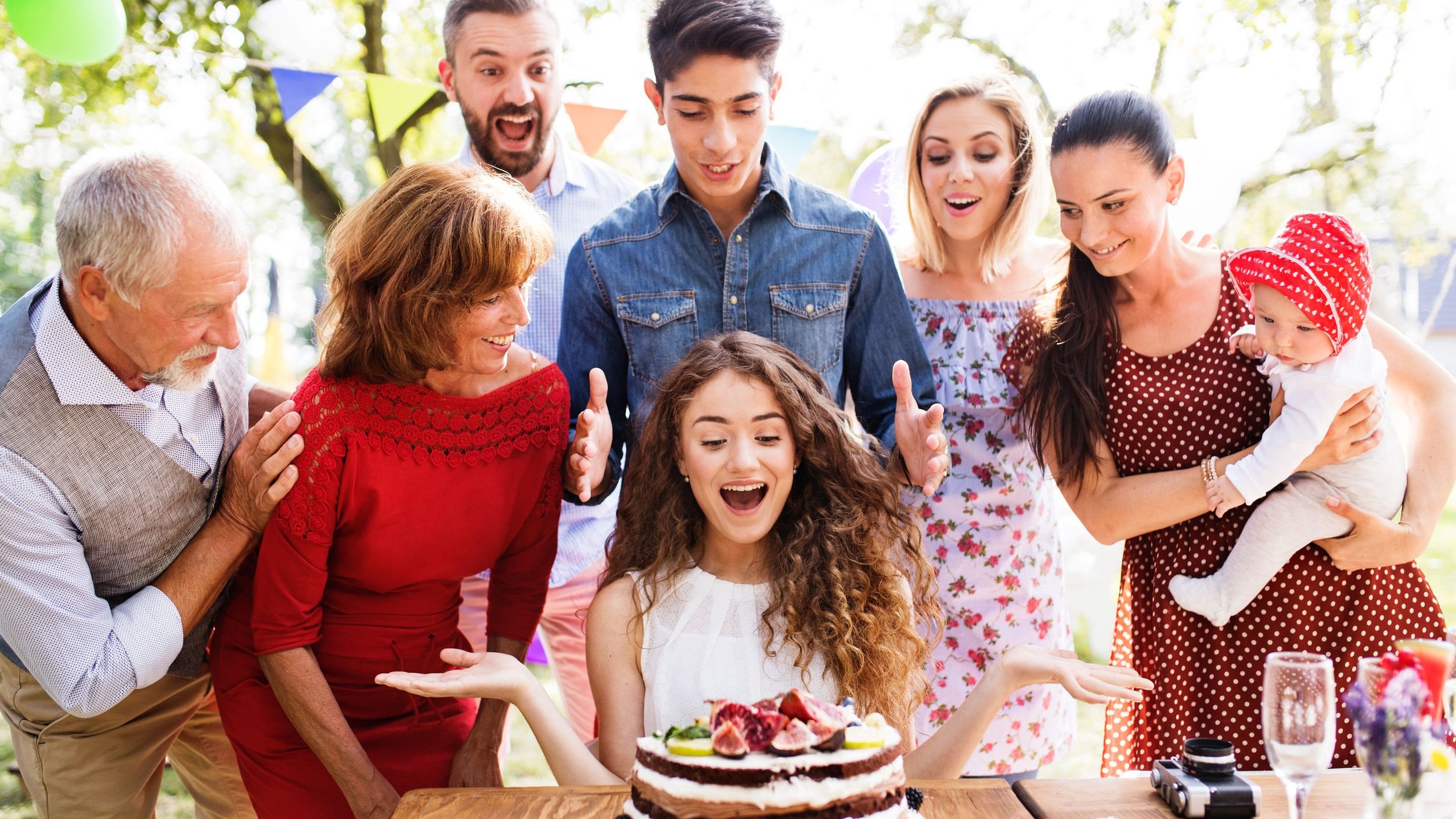 Pessoas comemorando aniversário ao redor de bolo