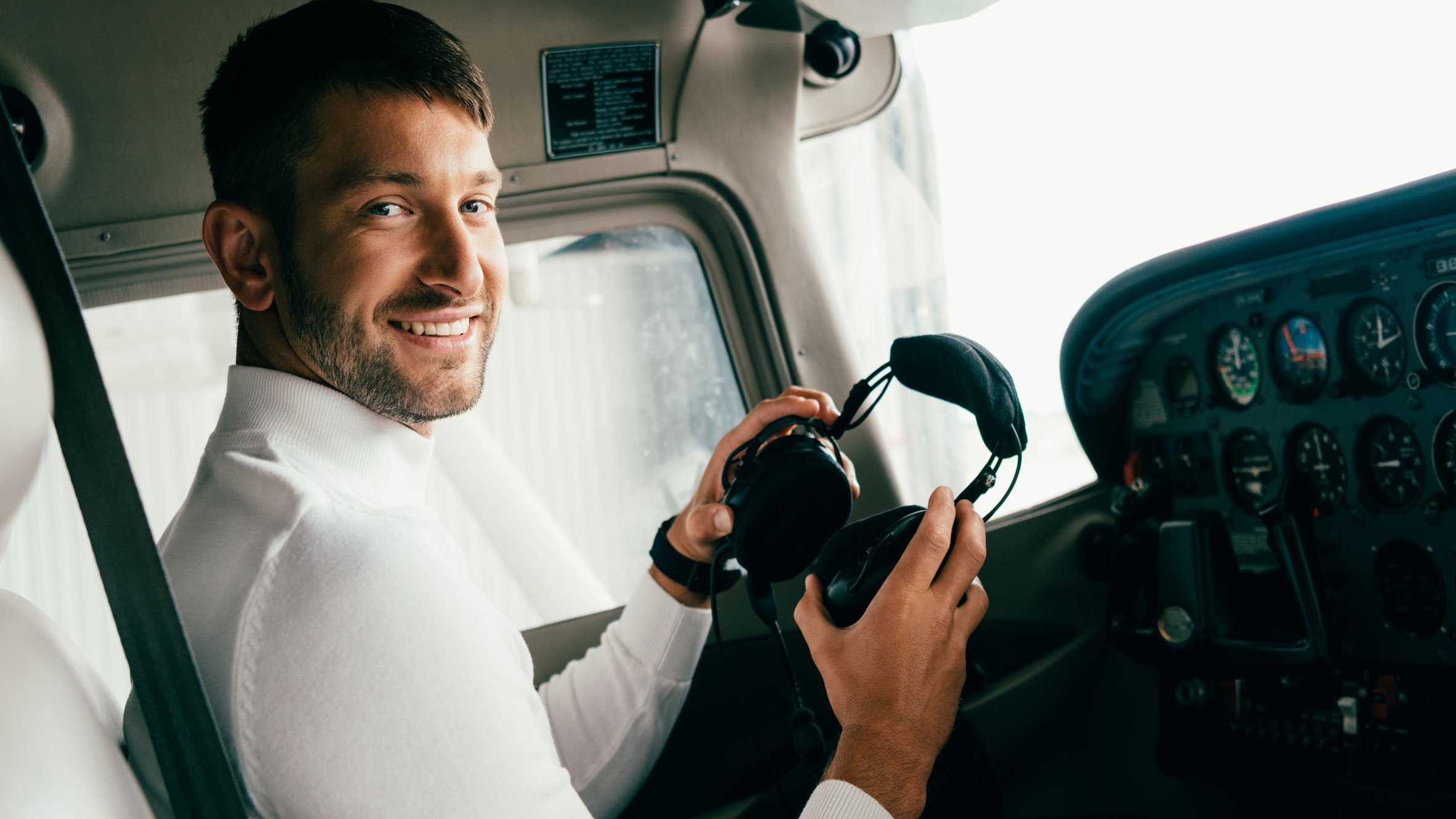 Homem piloto, sorrindo.