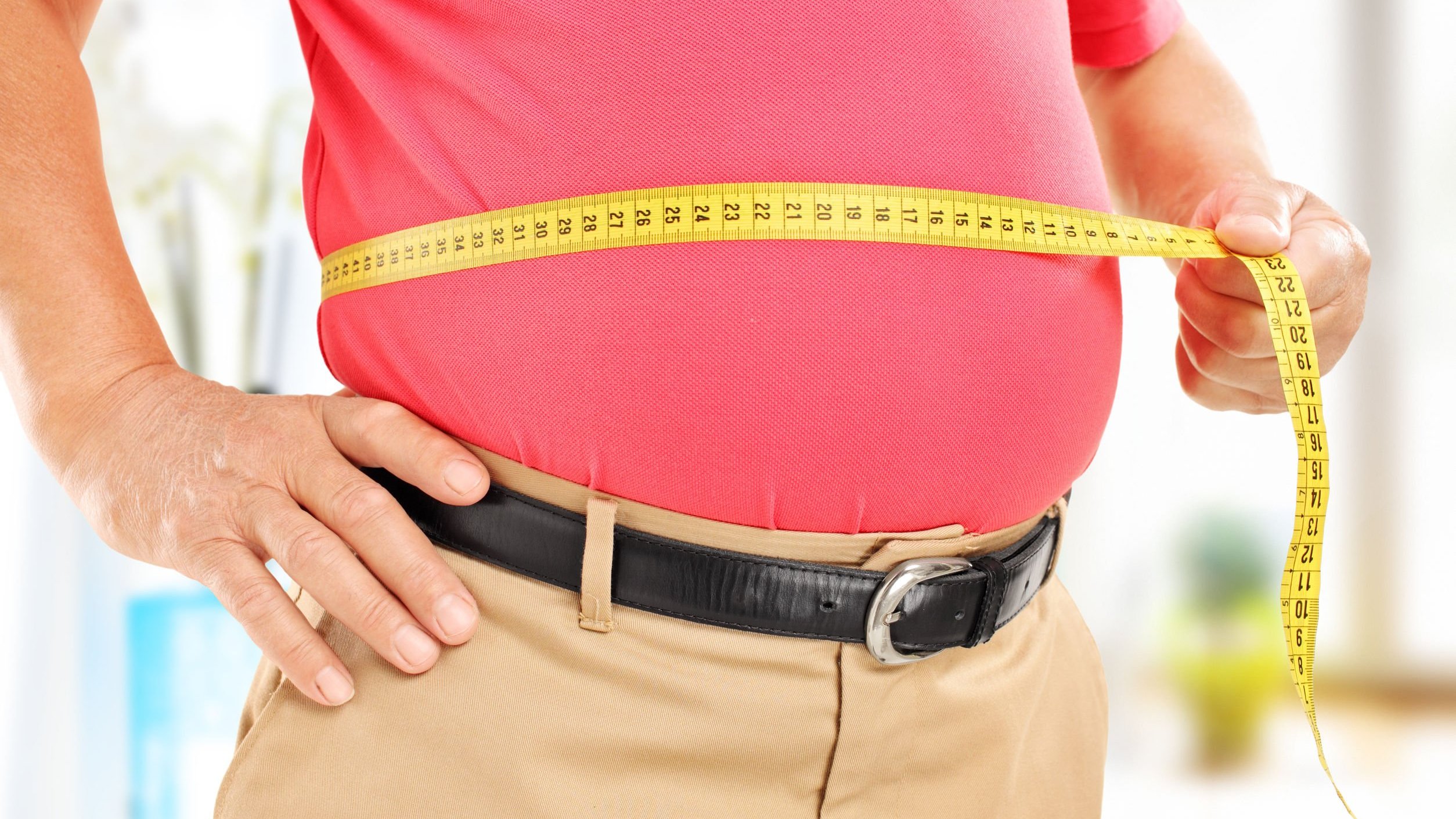 Homem obeso com fita métrica na barriga