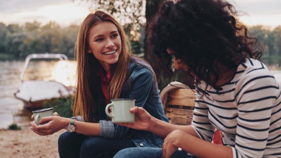 Duas mulheres conversando e segurando uma caneca