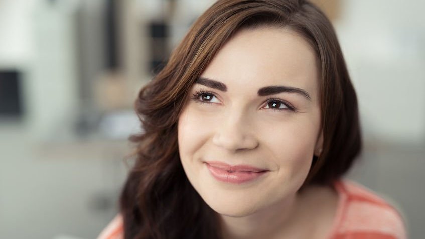 Mulher sorrindo enquanto olha para cima