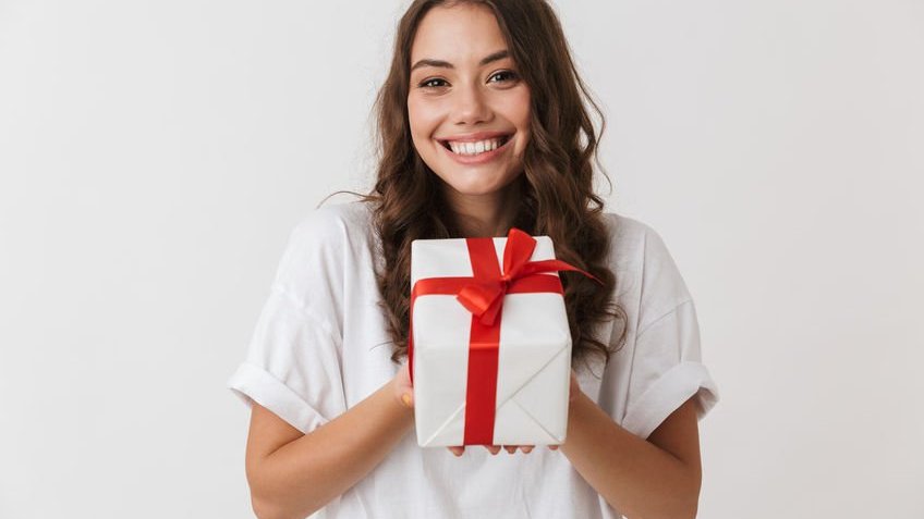 Menina sorrindo e segurando presente