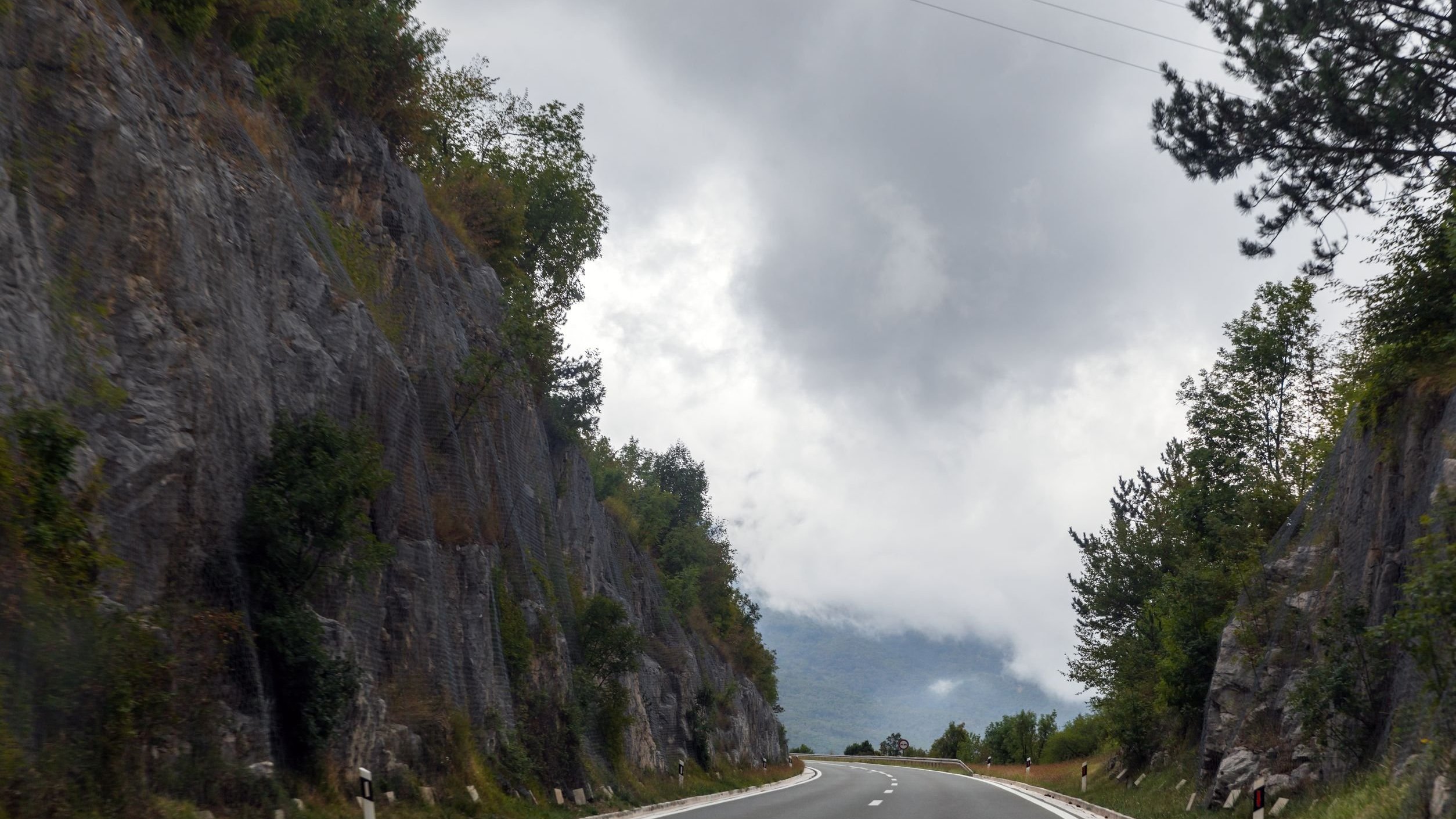 Estrada com céu nublado à frente.