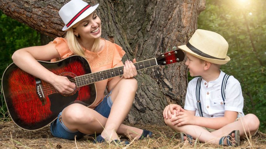 Mulher tocando violão para criança