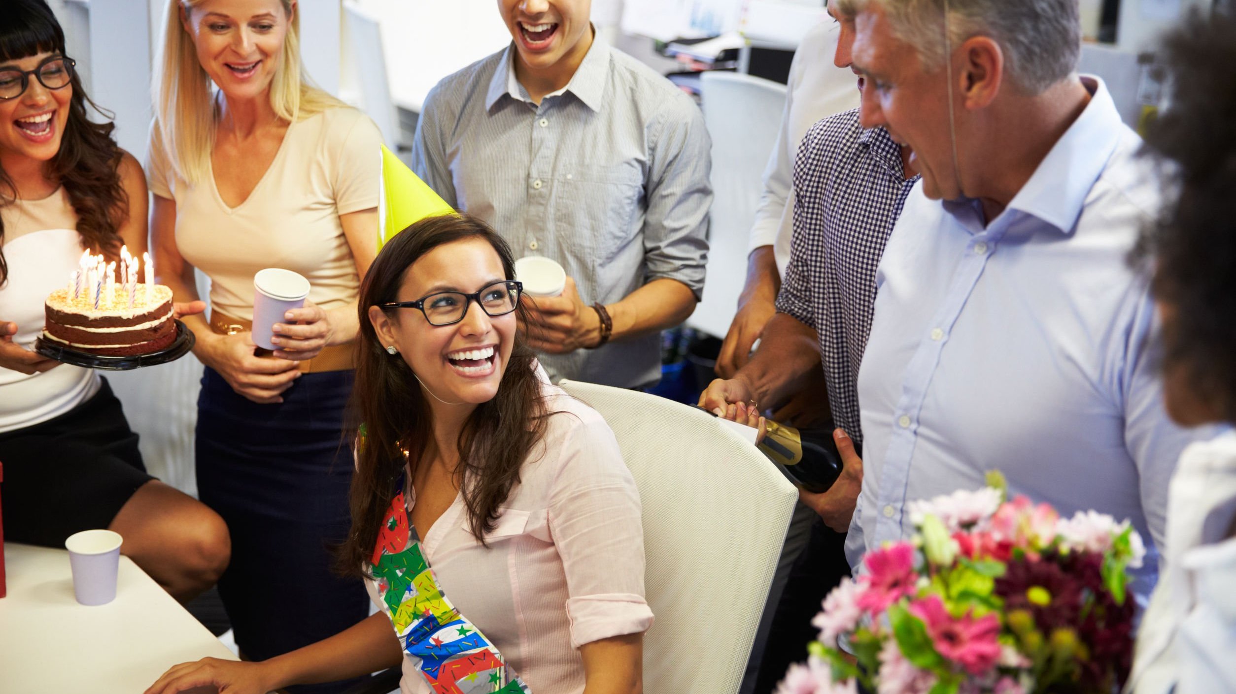 Pessoas reunidas comemorando aniversário em escritório