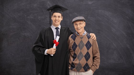 Garoto com roupa de formatura abraçado com o avô