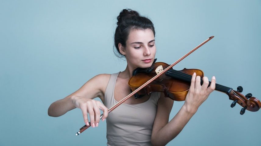 Uma jovem com um violino sobre o fundo azul