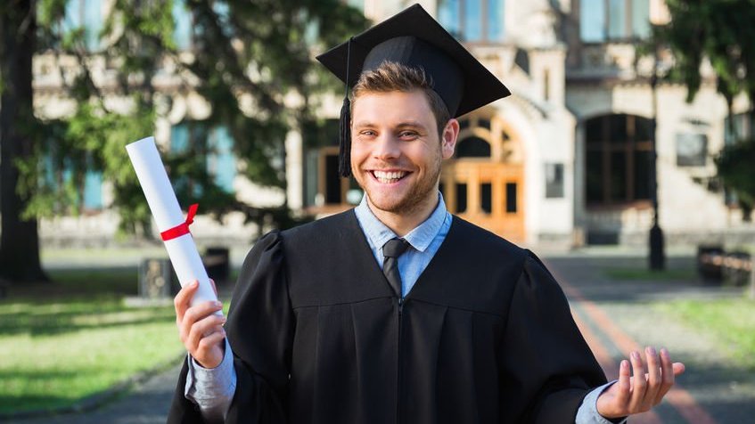 Homem sorrindo com roupa de formatura