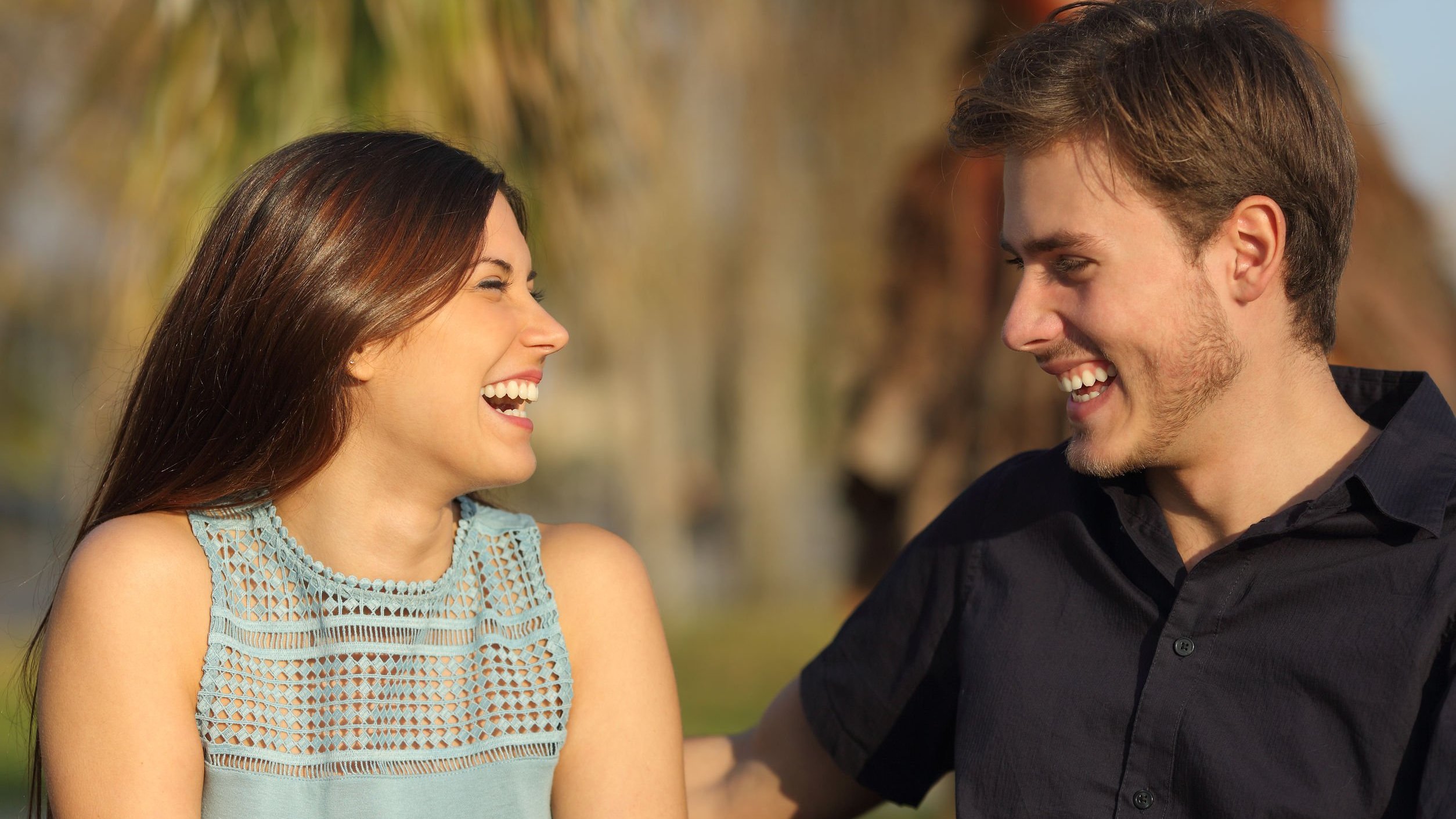 Homem e mulher sorrindo conversando.