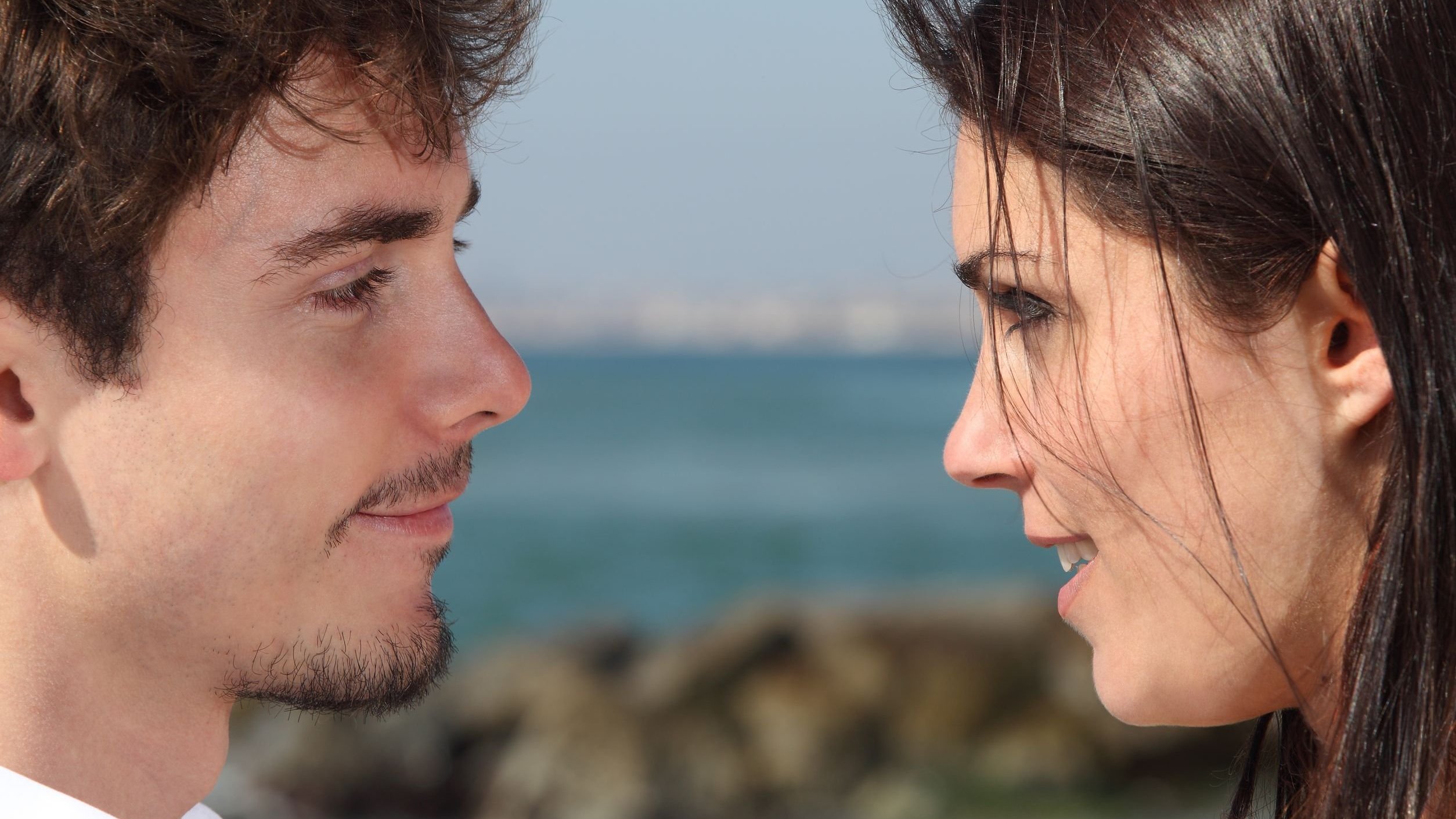 Homem e mulher se olhando e sorrindo.