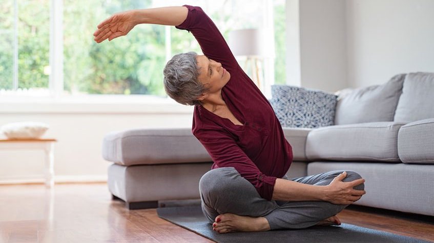 Mulher praticando Yoga em sala de estar
