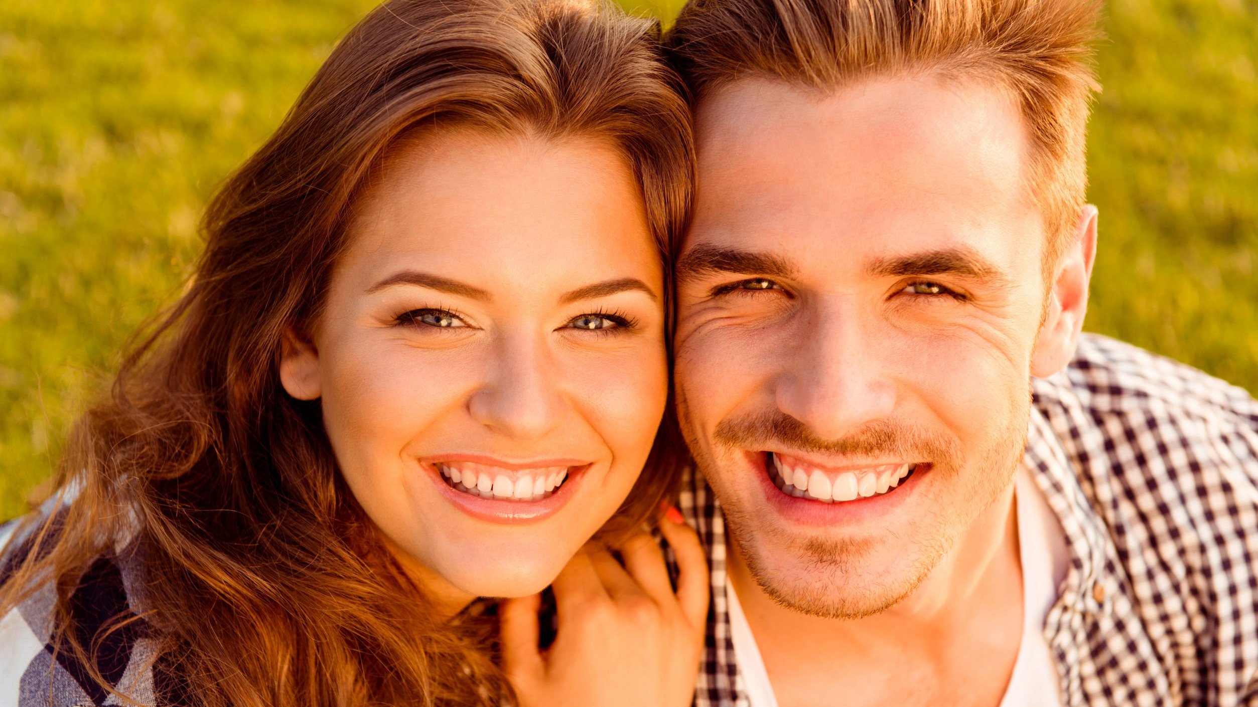 Casal sorrindo, se abraçando.