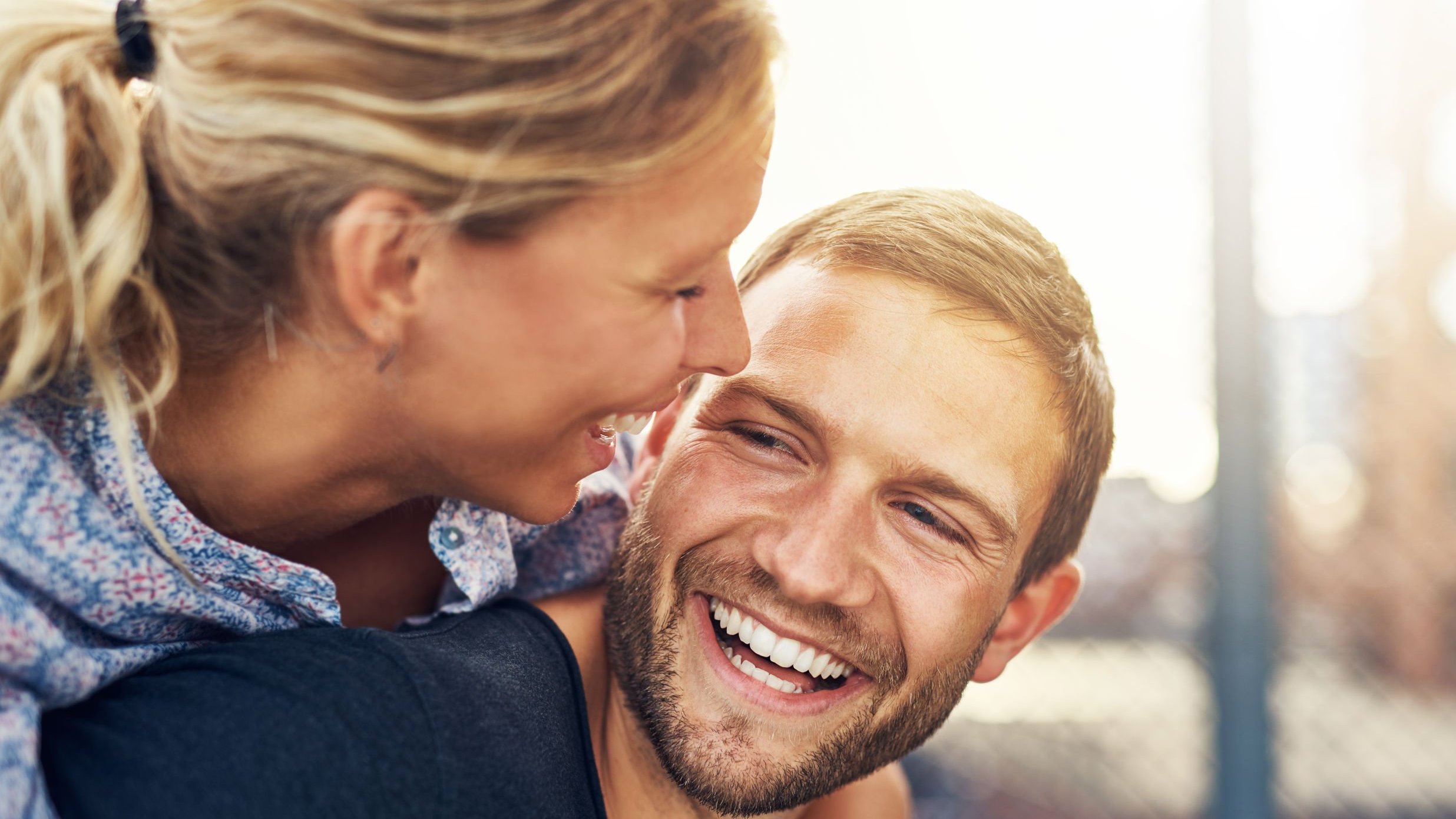 Casal sorrindo e se abraçando