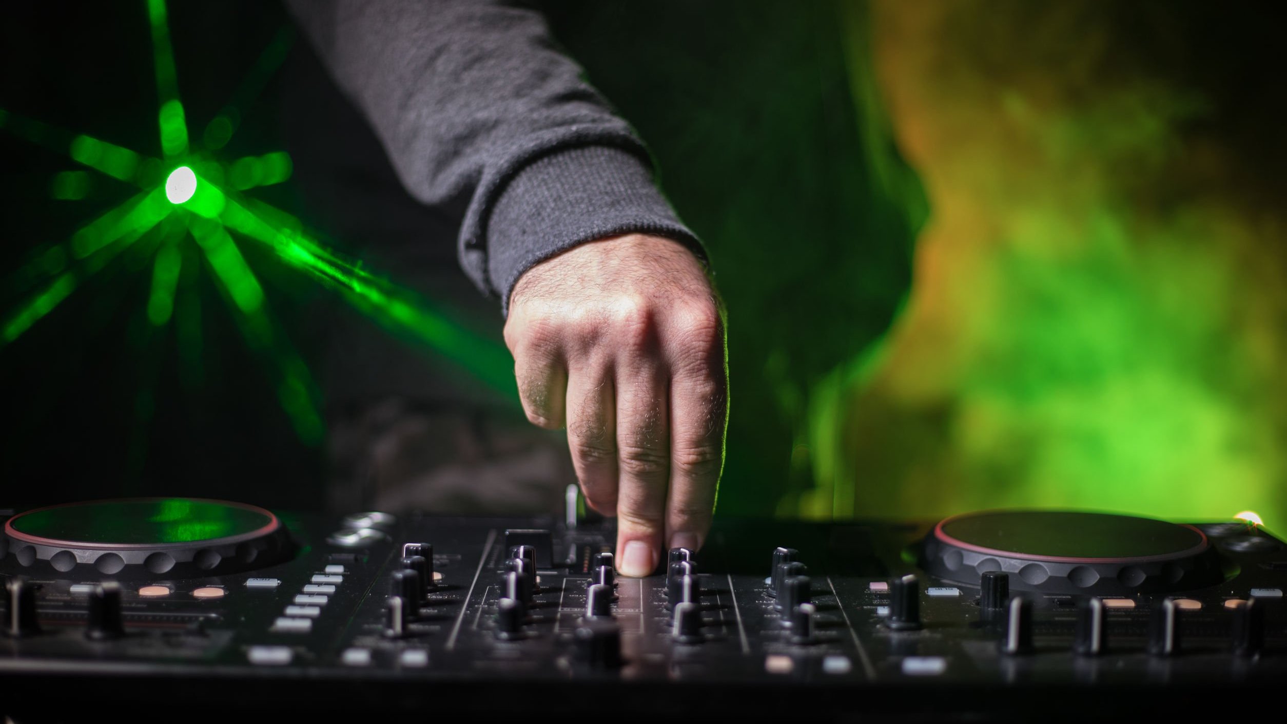 Mão de DJ em mesa de som.