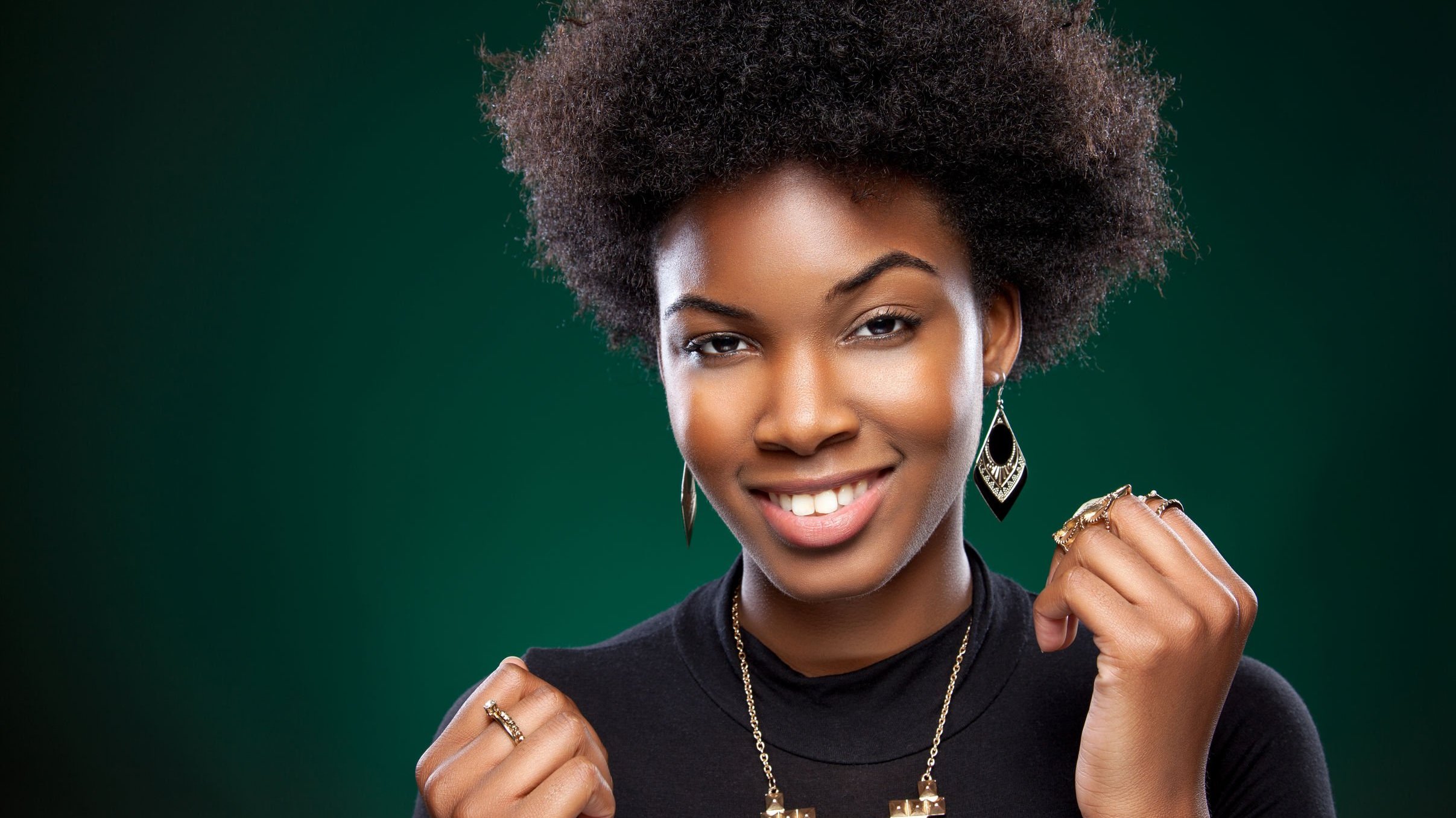 Mulher negra sorrindo com os punhos erguidos