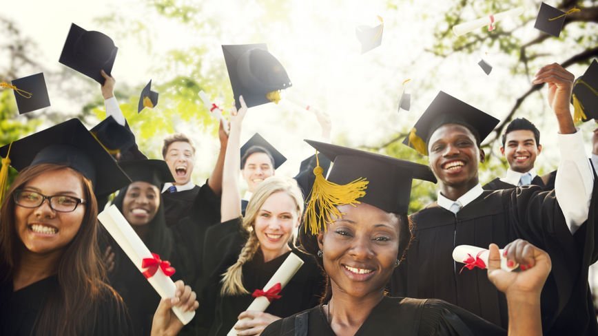 Estudantes segurando diploma comemorando a formatura