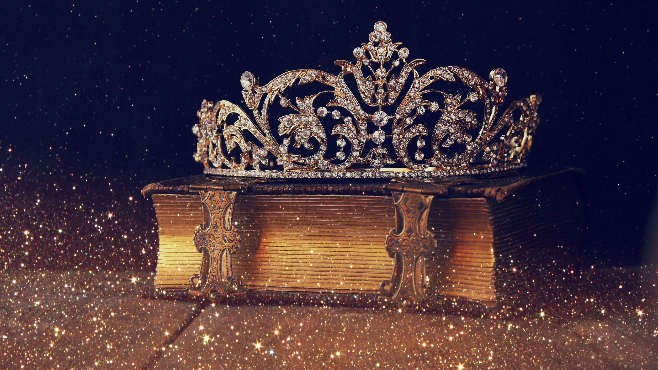 Coroa posta sobre um livro em um cenário brilhante