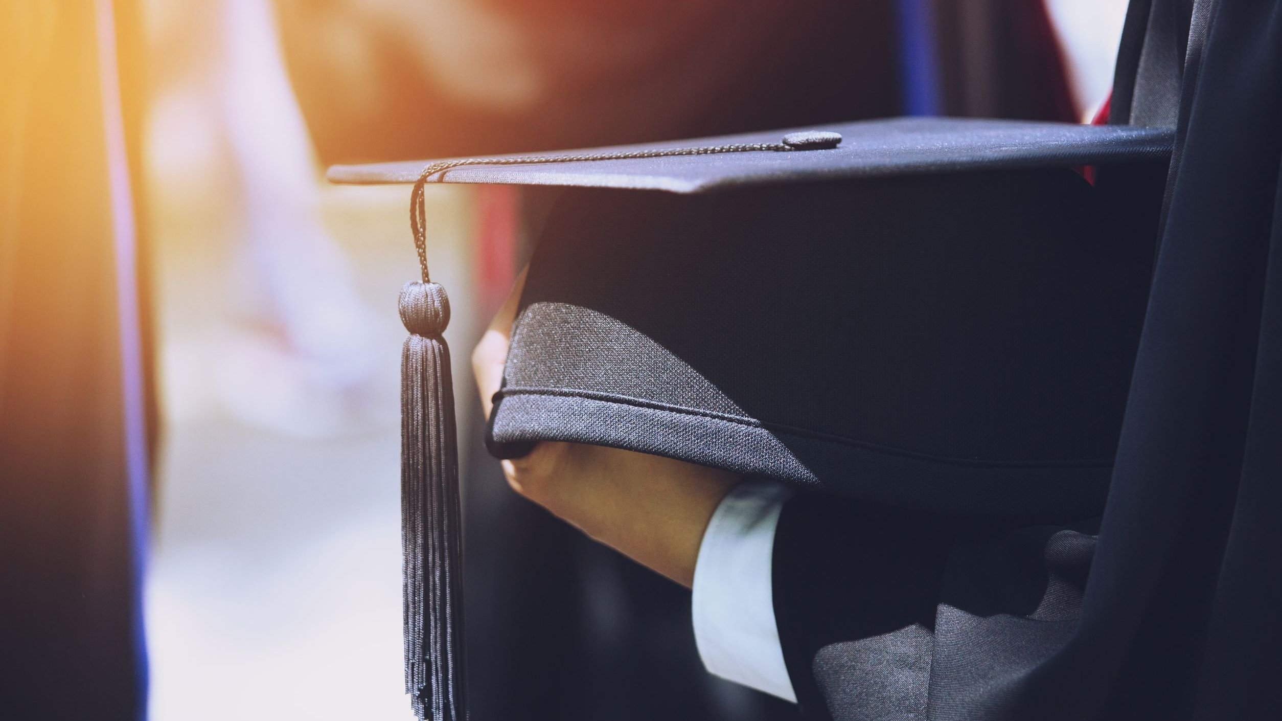 Chapéu de formatura sobre mão de formando