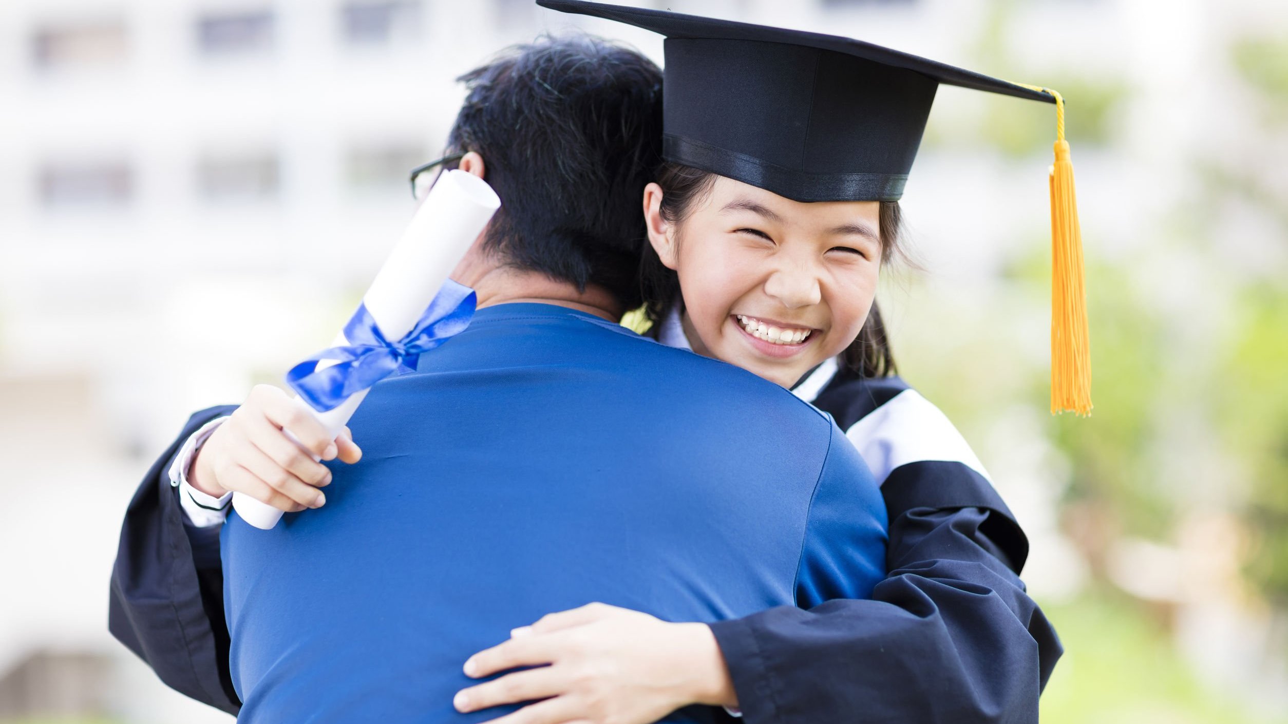 Graduanda sorrindo abraça homem