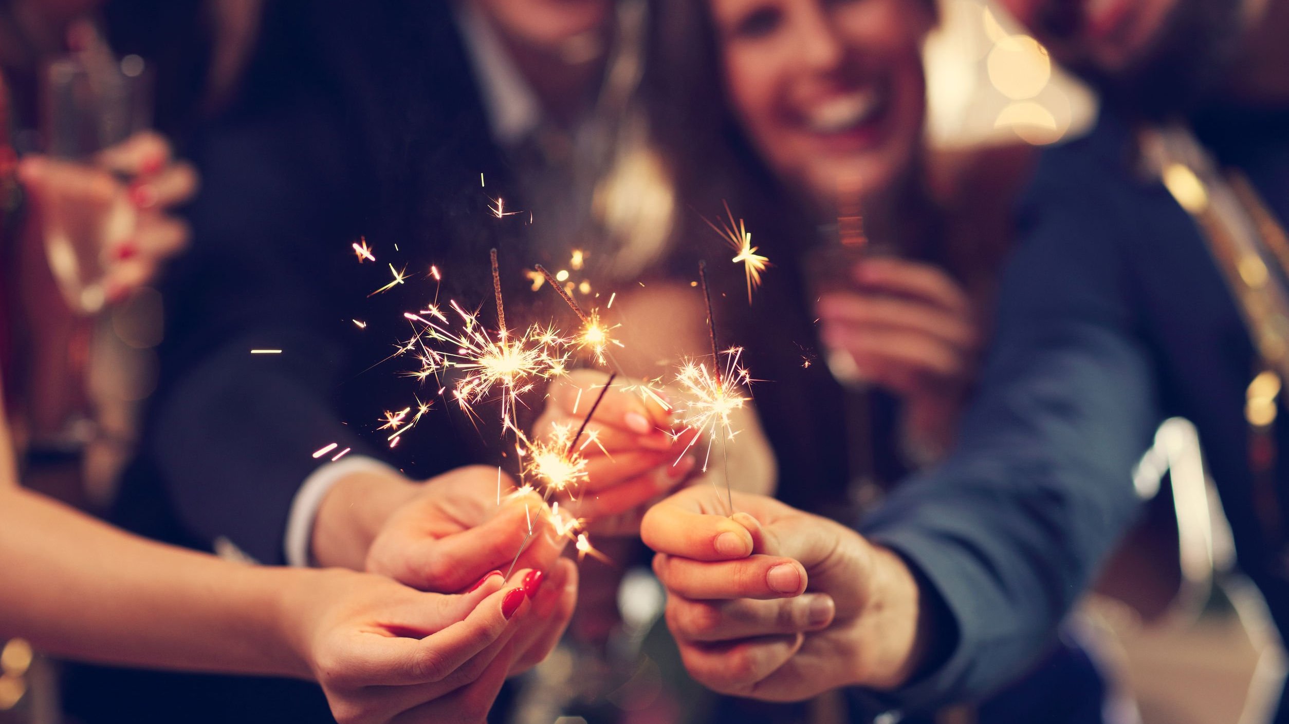 Grupo de amigos sorri e segura velas estrelas