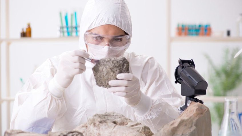 Geólogo analisando uma pedra no laboratório