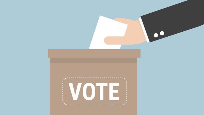 Conceito de votação com uma mão colocando o papel de voto na urna