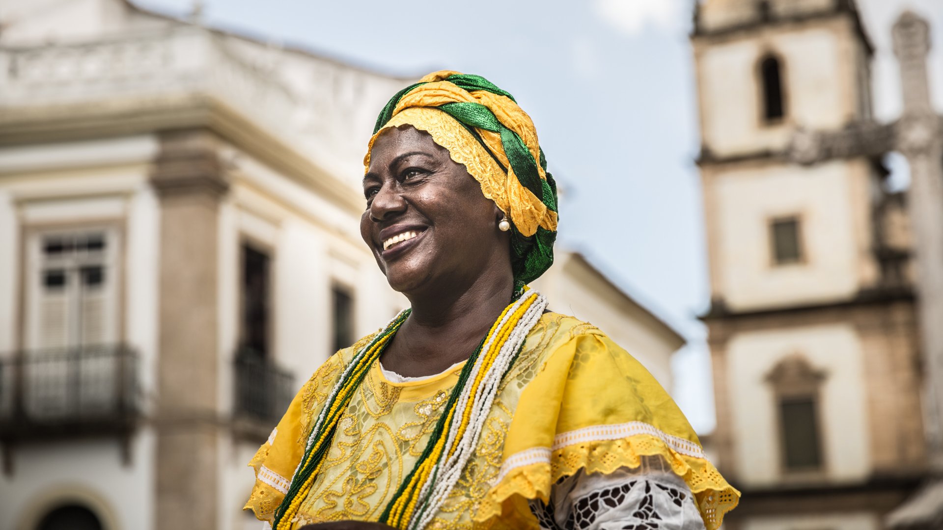 Mulher baiana sorrindo e usando vestimentas da Umbanda