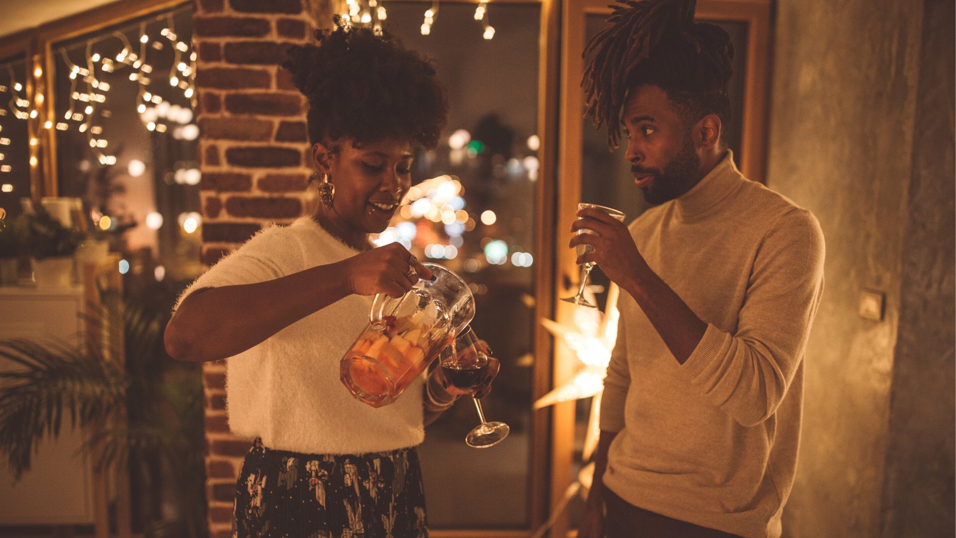 Casal comemorando o ano novo em casa tomando vinho