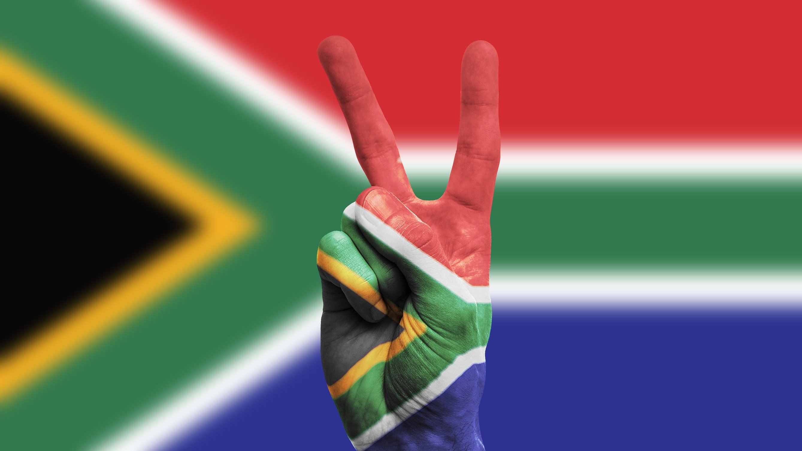 Mão pintada como a bandeira da África, fazendo sinal da paz