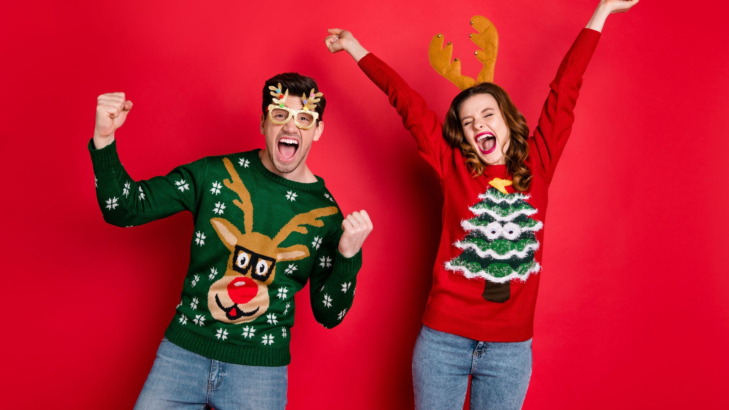 Roman Samborsky/123RF Homem e mulher vestidos com roupas de Natal, comemorando.