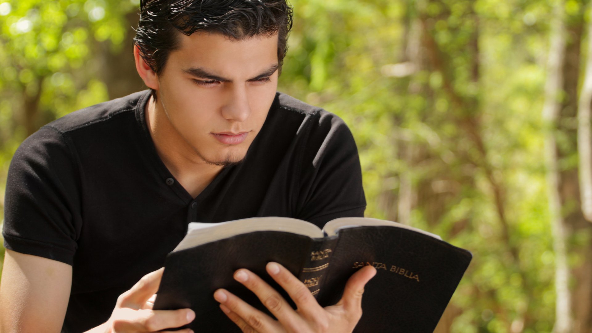 Размышляя над книгой писателю. Мужчина с Библией. Парень с Библией. Мужчина читает Библию. Библия в руках мужчины.