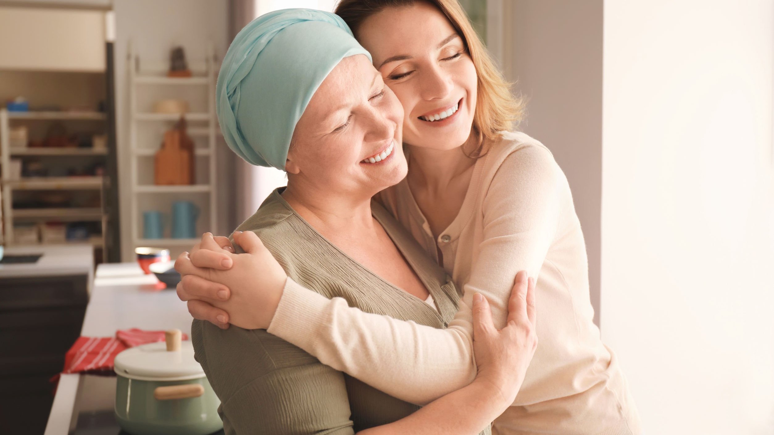 Filha abraçando mãe com câncer.
