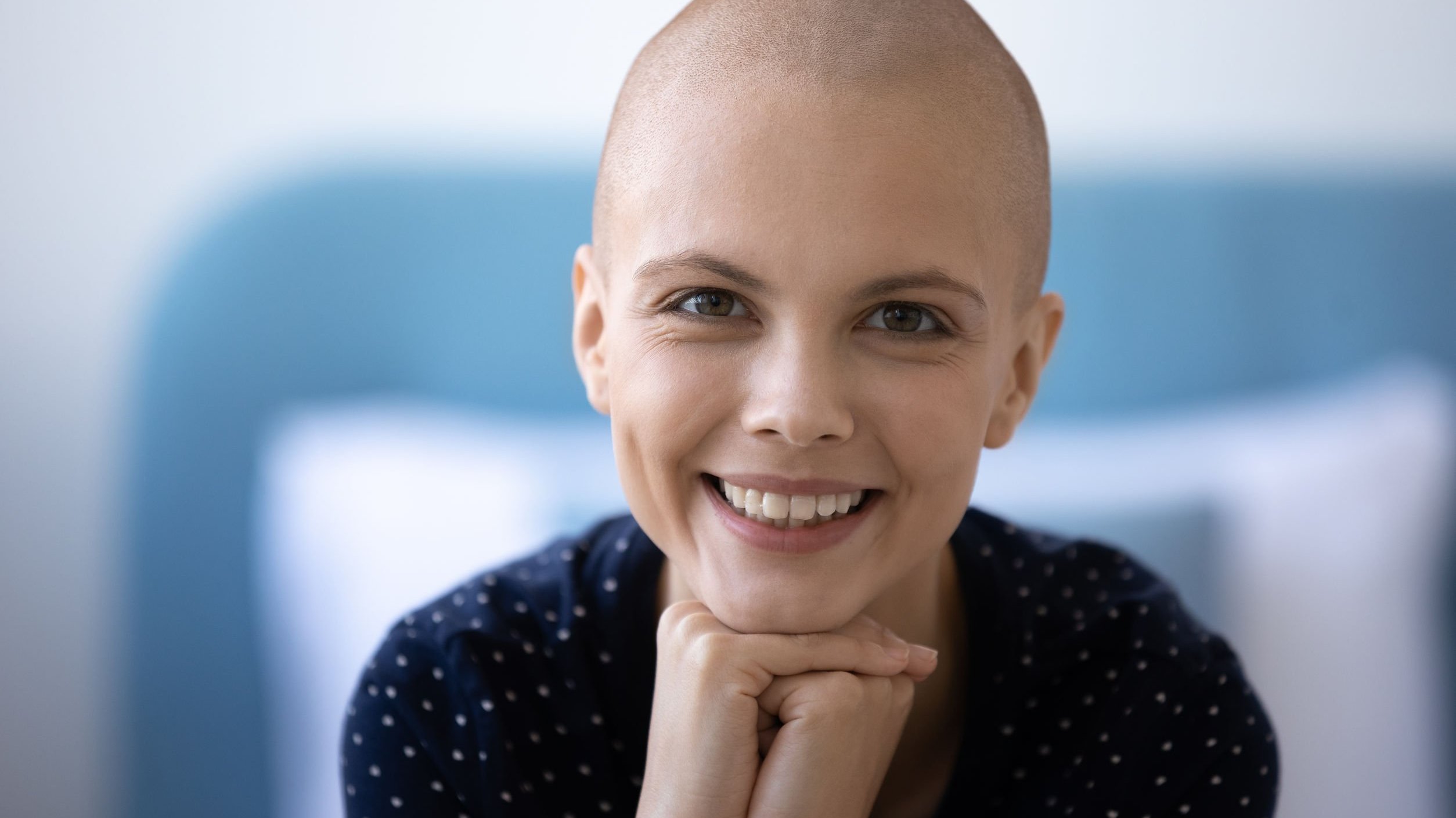 Menina careca sorrido, que venceu o câncer.
