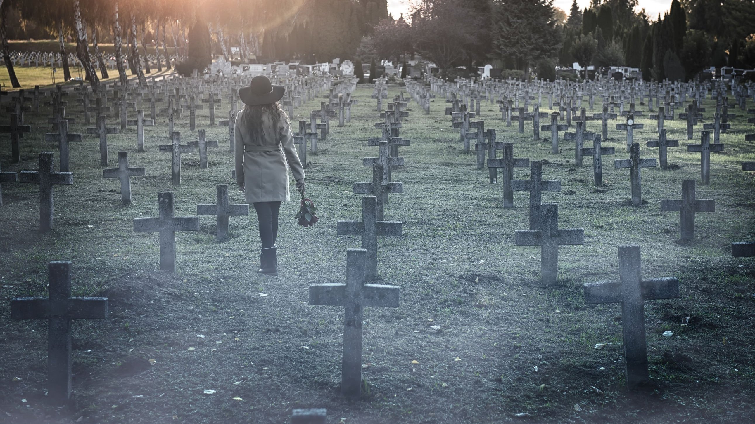 Mulher caminhando em cemitério.