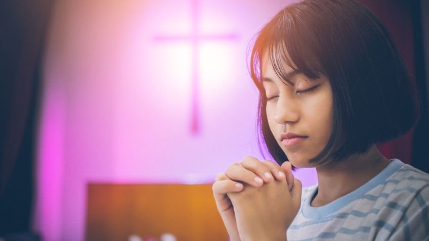 Menina asiática orando
