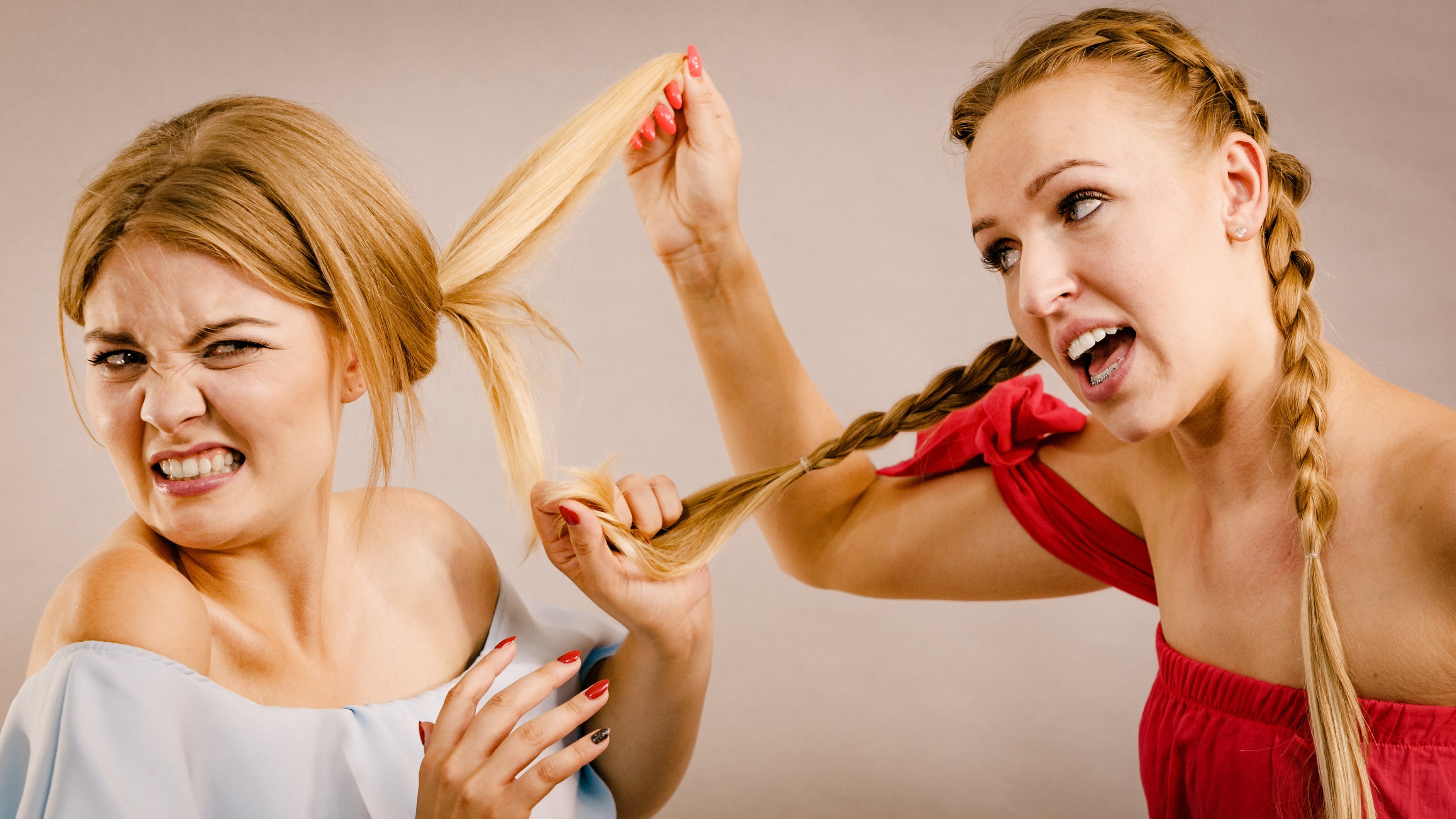 Duas mulheres puxando o cabelo uma da outra.