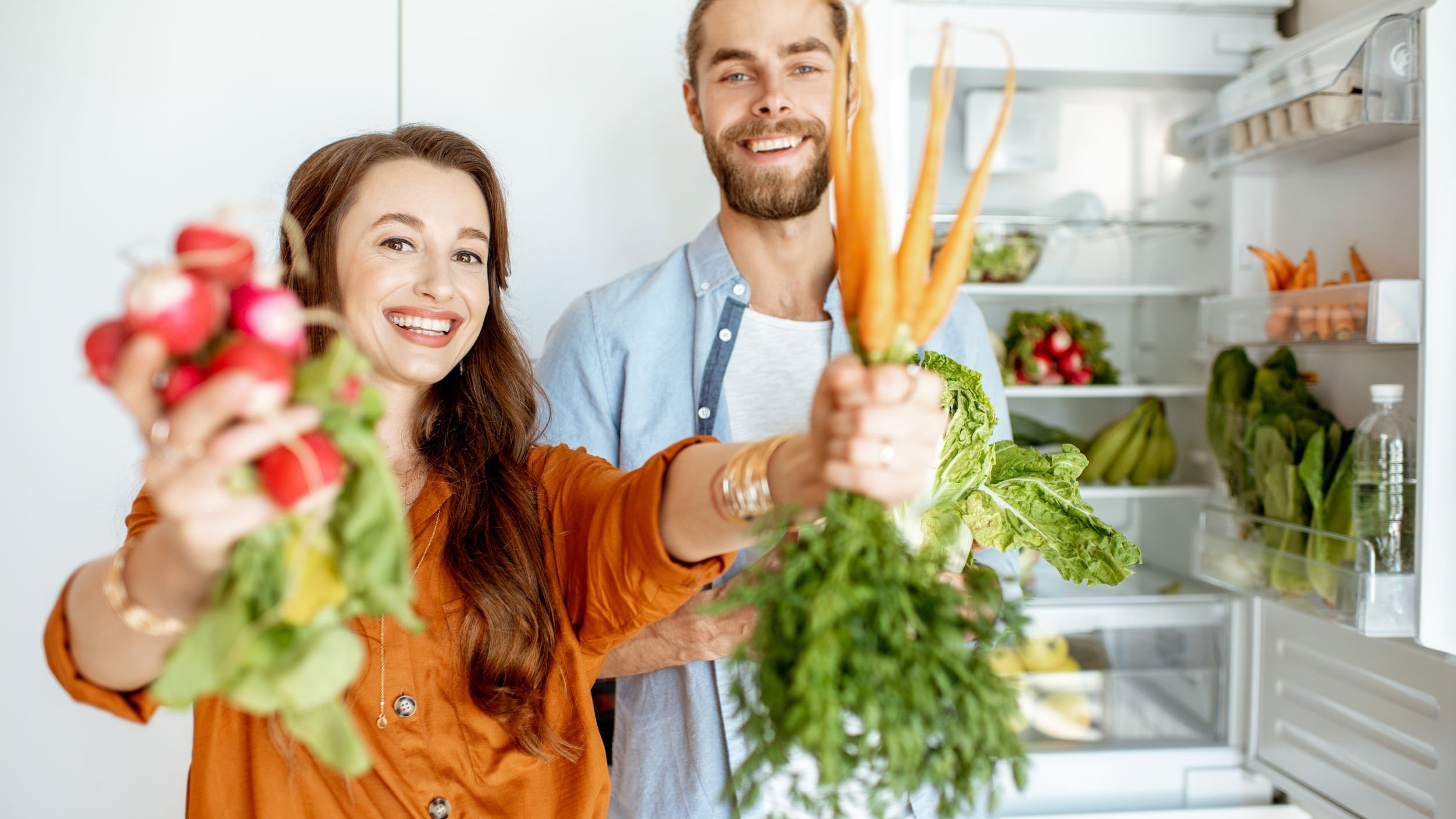 Homem e mulher segurando alimentos.