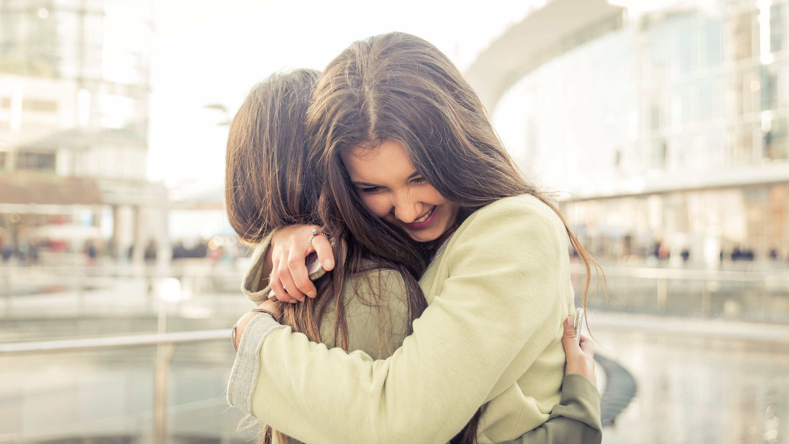 Duas mulheres amigas se abraçando.